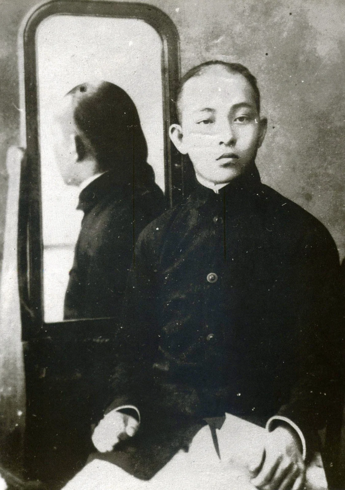 漢服を着て弁髪を結った少年期の許天徳の写真